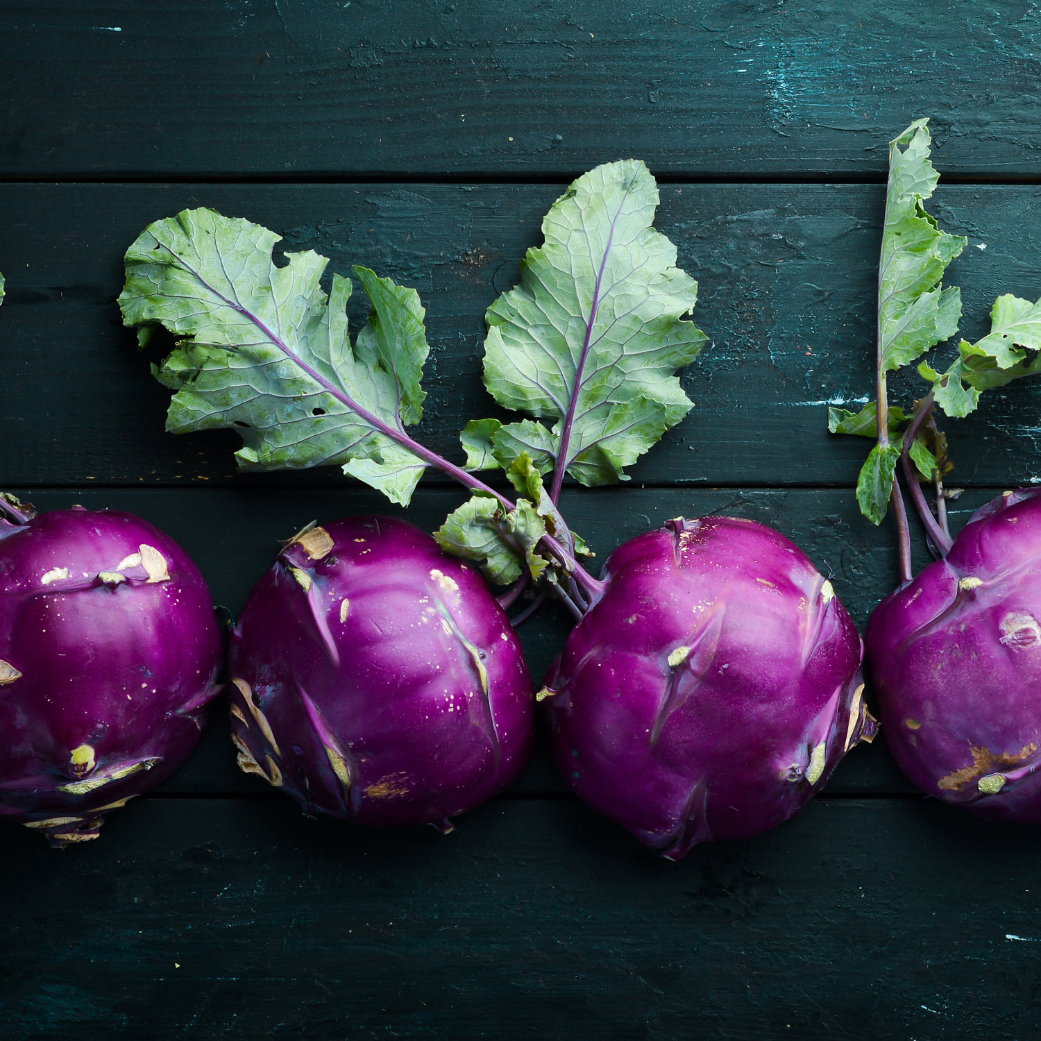 Cavolo rapa viola biologico fresco su sfondo in legno scuro