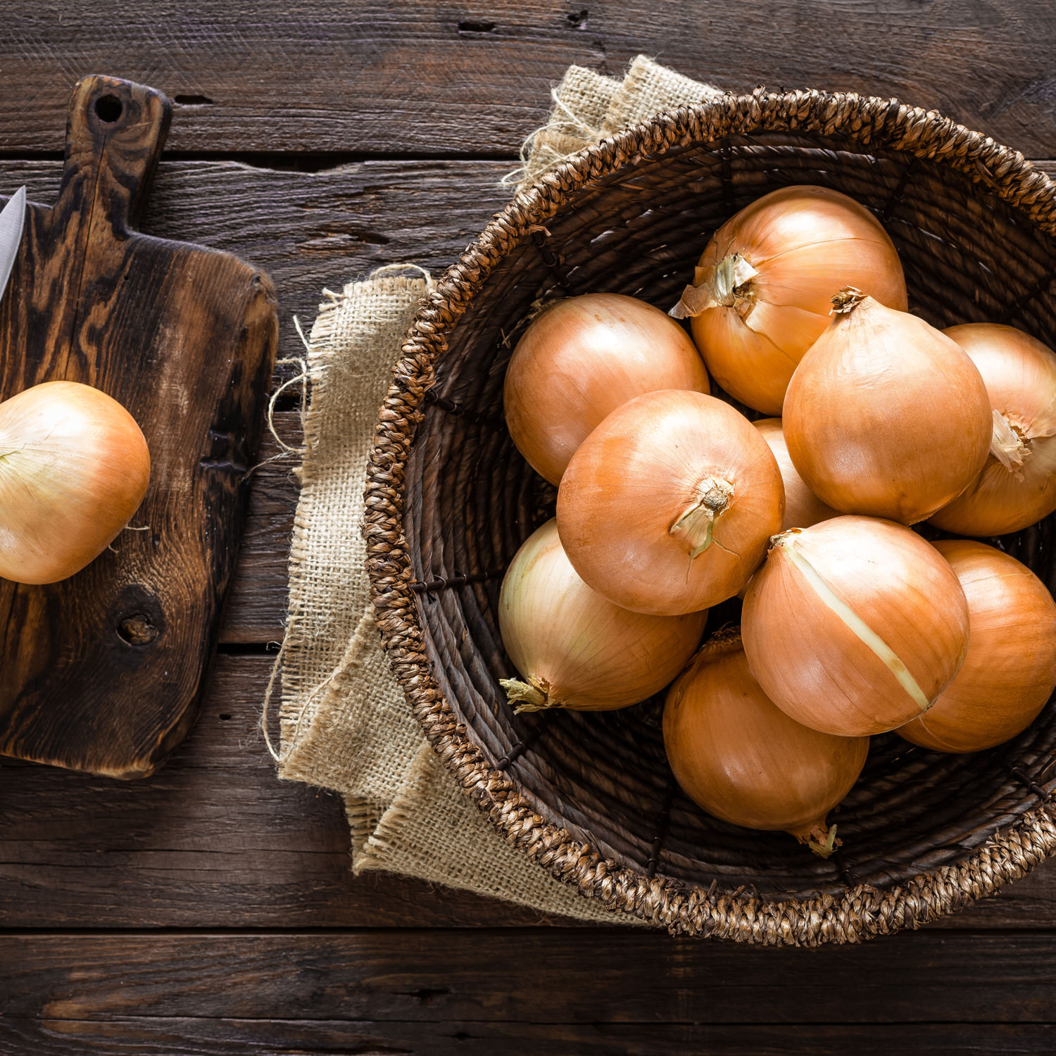 Cipolle dorate fresche raccolte in cesto rustico.