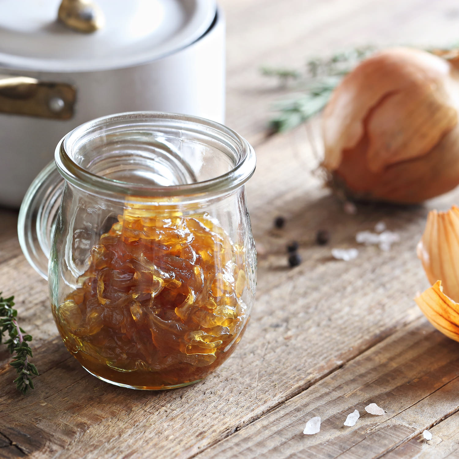 Composta di cipolle caramellate in barattolo di vetro su tavolo rustico.
