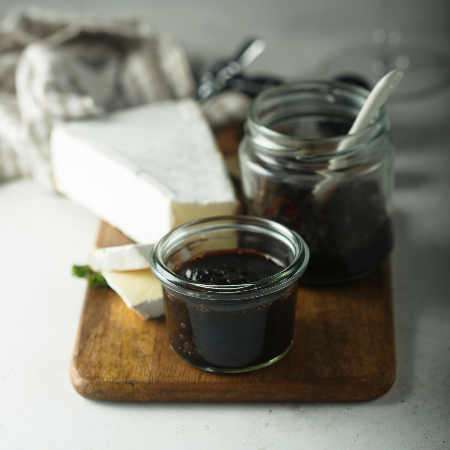 Composta di cipolle servita con formaggi su tagliere rustico.