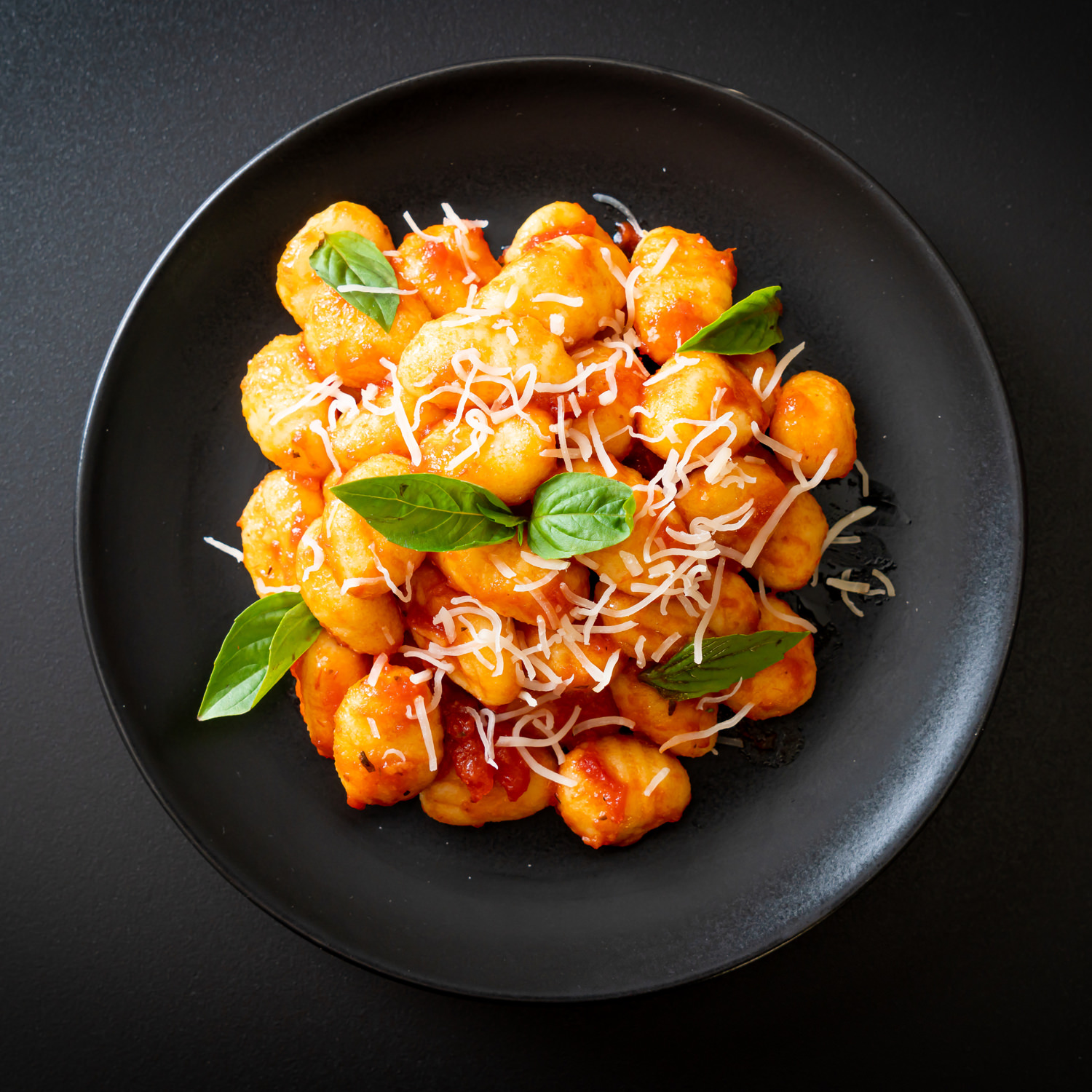 pasta al pomodoro con basilico in piatto nero