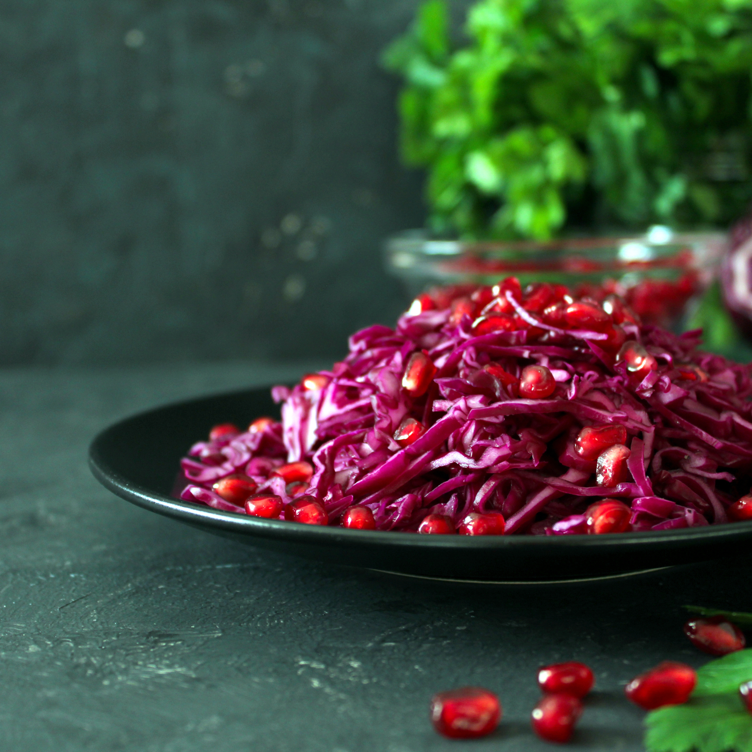Insalata di cavolo rosso fresco con chicchi di melograno su piatto scuro